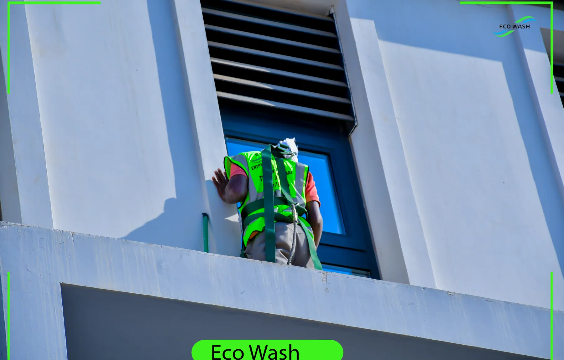 Technicien EcoWash en hauteur devant la façade vitrée Inchcape