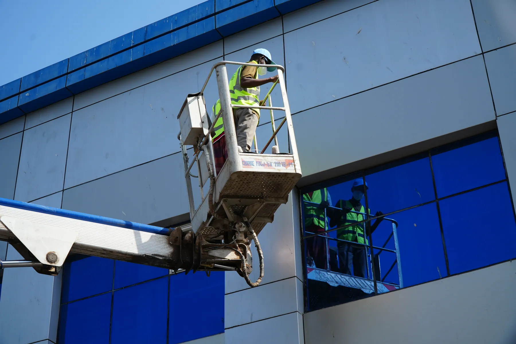 Équipe EcoWash travaillant en hauteur sur la façade vitrée d’un bâtiment
