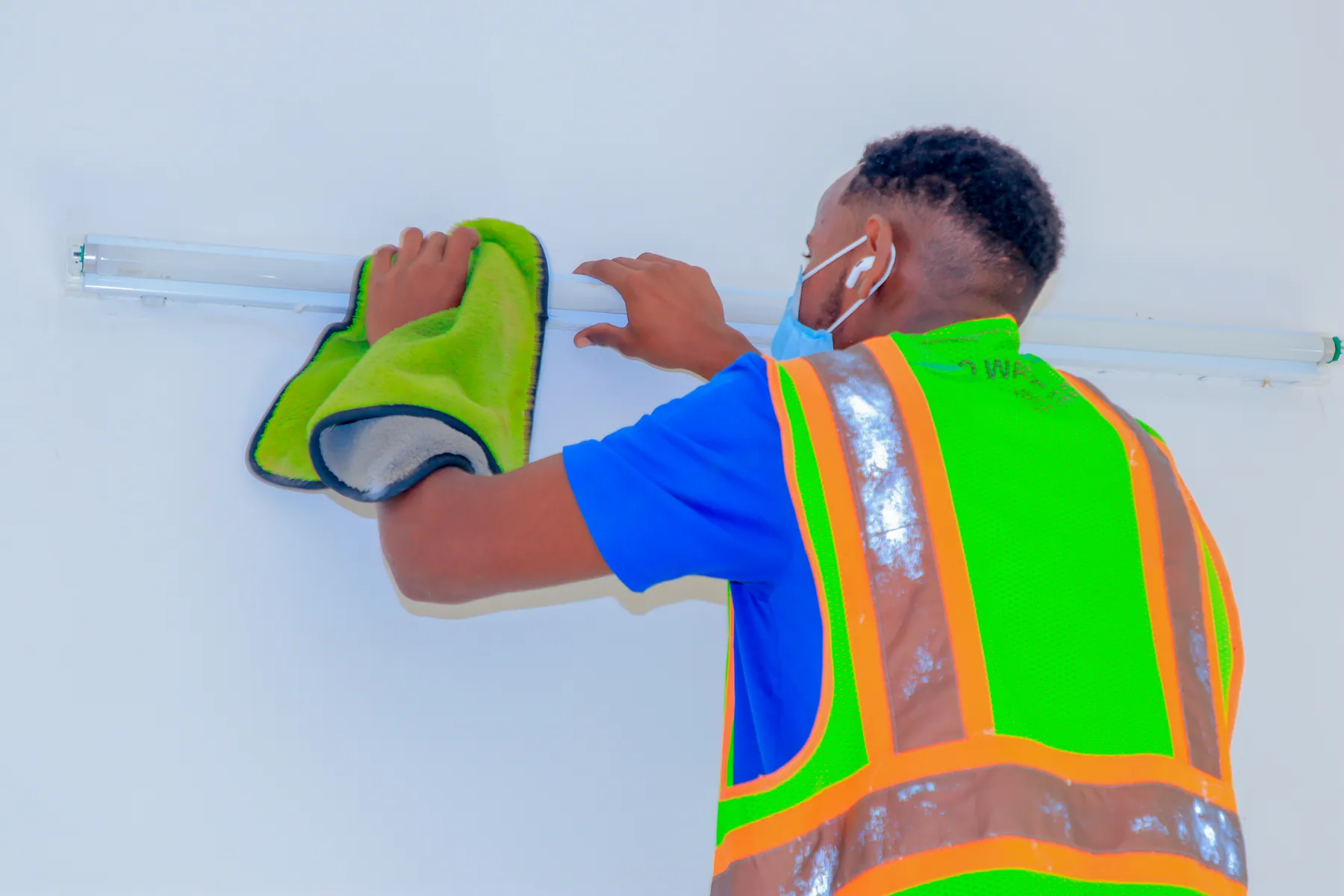 Technicien réalisant les finitions de nettoyage dans un bâtiment rénové