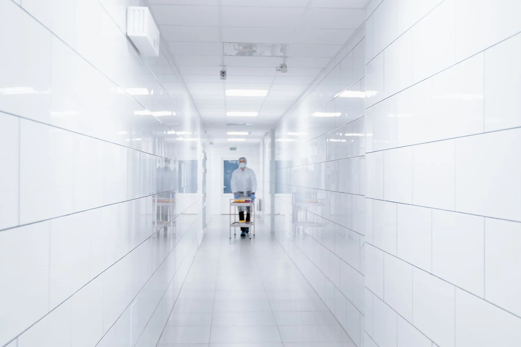 Professionnel de l’entretien préparant une intervention dans un couloir clinique