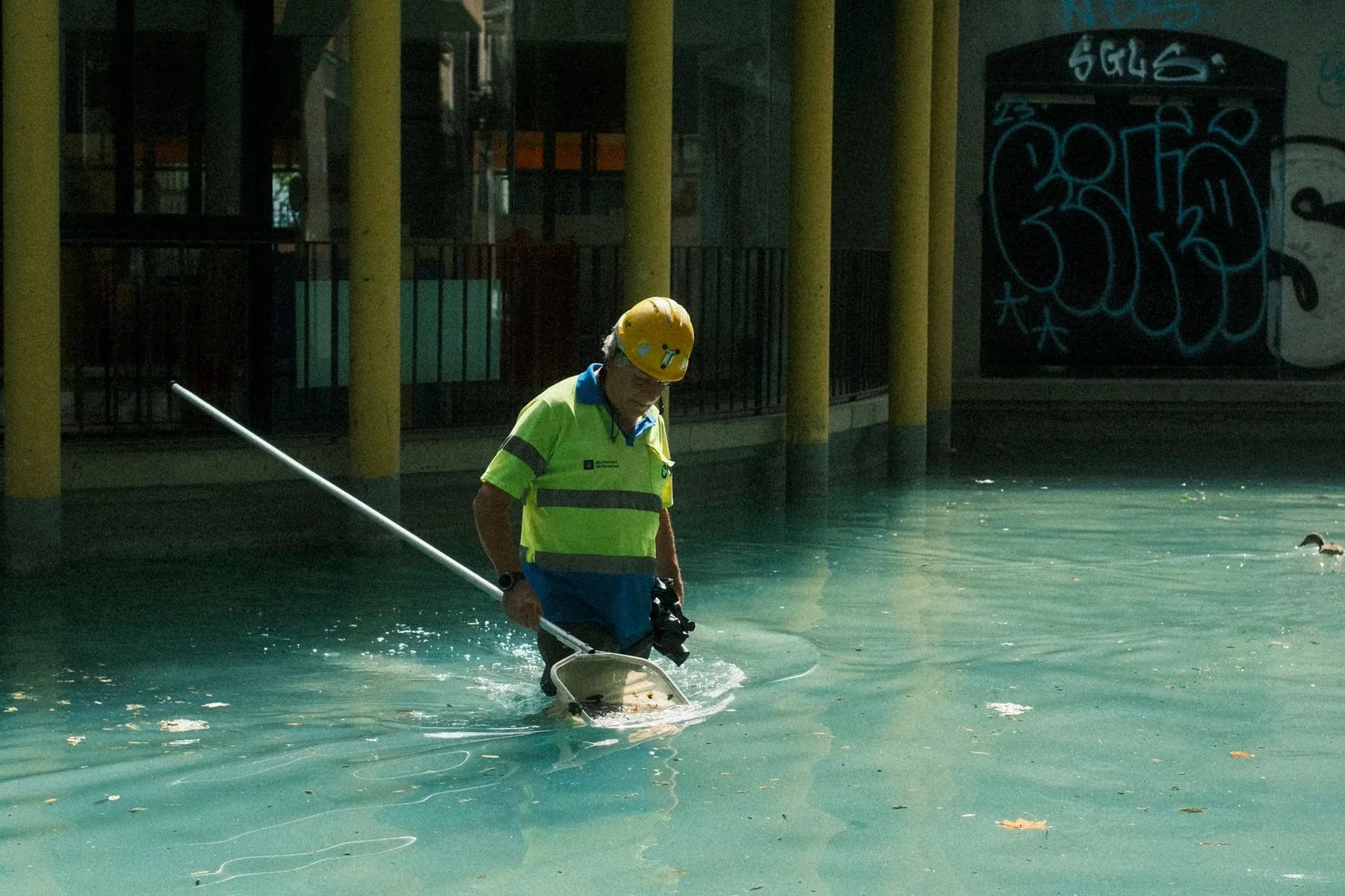 Professionnel nettoyant la ligne d’eau d’une piscine extérieure